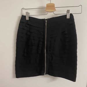 Black skirt with pleating all around and zipper down the front